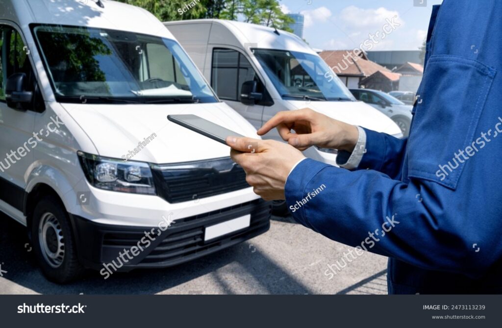 stock-photo-manager-with-a-digital-tablet-on-the-background-of-vans-fleet-management-2473113239